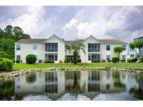 Inviting condo exterior overlooking tranquil pond with lush landscaping and calming reflections at 8925 Duckview Dr. # A, Surfside Beach, SC 29575