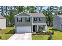 Charming two-story home featuring a welcoming front porch, manicured lawn, and attached two-car garage at 1020 Sennema Circle, Myrtle Beach, SC 29588