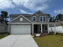 Charming two-story home featuring a two-car garage, gray siding, and a well-manicured front yard at 1023 Laconic Dr., Myrtle Beach, SC 29588