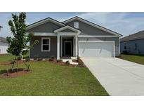 Charming one-story home with gray siding, well-manicured lawn, and attached two-car garage at 1034 Laconic Dr., Myrtle Beach, SC 29588