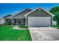 Charming single-story home with a well-manicured lawn, inviting front porch, and attached two car garage at 113 Adelphia Rd., Loris, SC 29569