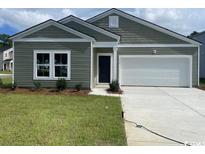 Charming single-story home featuring a well-maintained lawn, a two-car garage, and neutral toned siding at 1170 Silver Perch Place, Sunset Beach, NC 28468