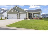 Charming single-story home with a well-manicured lawn, a two-car garage, and inviting curb appeal at 122 New Paradise Way, Myrtle Beach, SC 29588