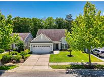 Charming single-story home with well-manicured lawn, lush trees, and attached two-car garage at 1290 Prescott Circle, Myrtle Beach, SC 29577