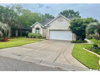 Charming single-story home with a well-manicured lawn, mature landscaping, and a two-car garage at 1504 Saint Thomas Circle, Myrtle Beach, SC 29577