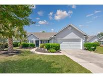 Charming single-story home with a well-manicured lawn, lush landscaping, and a two-car garage at 1527 Hallborough Dr., Surfside Beach, SC 29575