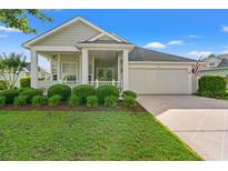 Charming home with manicured lawn, covered porch, and two-car garage on a sunny day at 1631 Murrell Pl., Murrells Inlet, SC 29576