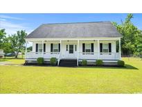 Charming single-story home featuring a welcoming front porch and well-manicured lawn at 1763 Lipscomb Rd., Mullins, SC 29574