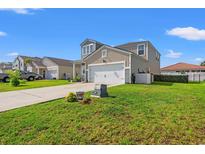 Two-story home featuring a two-car garage, a well maintained lawn, and neutral colored siding at 348 Hidden Cove Dr., Little River, SC 29566