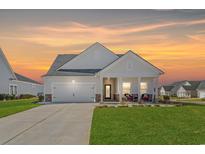 Charming single-Gathering home featuring a well-manicured lawn and a covered front porch with comfortable seating at 4000 Da Vinci Dr., Myrtle Beach, SC 29579