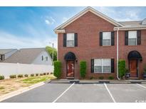 Charming brick townhome with black shutters and manicured landscaping, offering great curb appeal at 404 1St Ave. N # H, North Myrtle Beach, SC 29582