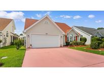 Charming home featuring a red-colored driveway, attached garage, and manicured landscaping at 425 Mallard Lake Circle, Surfside Beach, SC 29575
