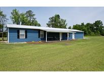 Charming single-story home with blue siding, white trim and a welcoming covered front porch at 445 W Willow Pond Rd., Johnsonville, SC 29555