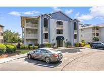 Inviting condo complex featuring manicured landscaping, classic architecture, and convenient parking spaces at 4520 Coquina Harbour Dr. # F-3, Little River, SC 29566