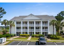 Inviting condo exterior featuring multiple balconies, lush landscaping, and ample parking spaces at 4940 Windsor Green Way # 301, Myrtle Beach, SC 29579