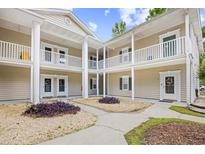 Attractive condo exterior with white pillars, balconies, manicured landscaping and inviting walkway at 5406 Sweetwater Blvd. # 5406, Murrells Inlet, SC 29576