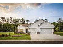 Charming single-Gathering home featuring a three-car garage, manicured lawn, and craftsman-style accents at 6080 Zoe Way, Myrtle Beach, SC 29588