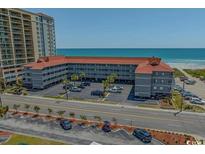 A condo complex with a gray facade is near a sandy beach and has ocean views at 613 S Ocean Blvd. # N3, North Myrtle Beach, SC 29582