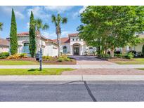 Charming single-story home featuring a red tile roof, manicured landscaping, and a paved brick driveway at 7202 Seville Dr., Myrtle Beach, SC 29572