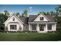 Charming craftsman-style home with white siding, a covered porch, and professionally landscaped front yard at 9 Sw Mashie Ct., Carolina Shores, NC 28467