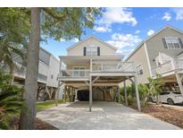 Inviting beach house on stilts featuring a spacious covered deck and ground-level parking at 108 N Oak Dr., Surfside Beach, SC 29575