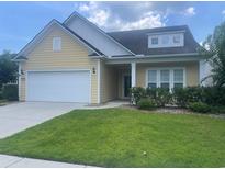Charming yellow home with white trim, a well-kept lawn, and attached two-car garage at 1141 Prescott Circle, Myrtle Beach, SC 29577