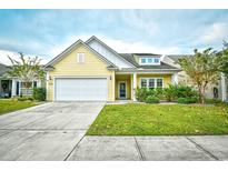 Charming yellow home featuring a two-car garage and well-manicured lawn at 1141 Prescott Circle, Myrtle Beach, SC 29577