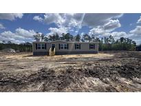 New construction, single-story home featuring horizontal siding, black shutters, and a wooden front porch at 1300 Rabbit Ln., Conway, SC 29526