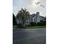 Charming home with a brick exterior, landscaped yard, and mature palm tree on a corner lot at 1426 Saint Thomas Circle # A 3, Myrtle Beach, SC 29577