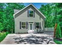 Charming home featuring a well-manicured lawn, updated siding, and classic black shutters at 1673 Carriage Ln., Little River, SC 29566