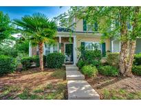 Inviting two-story home featuring neat landscaping, green shutters, a palm tree, and a charming brick-accented entrance at 3120 Mercer Dr., Conway, SC 29526
