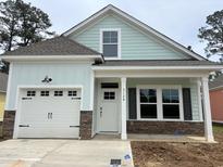 Charming single-Gathering home with a white garage door, stone accents, and light blue siding at 3129 Tiger Tail Rd., Conway, SC 29526