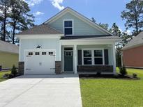Charming, light-blue single-Gathering home with a garage, well-kept lawn, and inviting curb appeal at 3129 Tiger Tail Rd., Conway, SC 29526