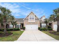 Charming two-story home with brick facade, manicured lawn, and two-car garage under a clear blue sky at 3210 Volterra Way # 3210, Myrtle Beach, SC 29579