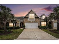 Charming brick home featuring a two-car garage, meticulously landscaped yard, and a welcoming driveway at 3210 Volterra Way # 3210, Myrtle Beach, SC 29579
