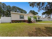 Charming single-story home with well-manicured lawn, garden beds and white picket fence at 3808 Mayfield Dr., Conway, SC 29526