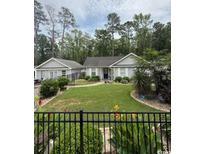 Charming home featuring a well-manicured lawn, mature landscaping, and a welcoming entrance at 3827 El Duce Pl., Myrtle Beach, SC 29588
