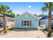 Charming single-story home with light blue siding, brown shutters, and a concrete driveway at 4338 Grande Harbour Blvd., Little River, SC 29566