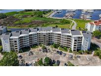 Waterfront condo building with manicured landscaping, parking, and marina access at 4440 Nassau Ct. # 308, Little River, SC 29566