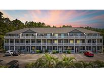 Attractive condo building featuring multi-level balconies, well-manicured landscaping, and convenient parking at 4506 West Harbor Ct. # U-15, Little River, SC 29566