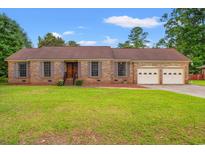 Charming brick ranch-style home featuring a two-car garage and a well-maintained front lawn at 5206 Columbia St., Conway, SC 29526