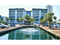 Beautiful waterfront condo complex with palm trees and a fountain in the foreground, offering serene views and coastal charm at 5905 South Kings Hwy. # 116B, Myrtle Beach, SC 29575