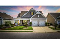 Charming two-story home with a well-manicured lawn, two-car garage, and colorful landscaping at 605 Ginger Lily Way, Little River, SC 29566