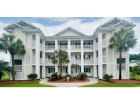 Inviting multi-story condo building with white siding, balconies, columns, and lush landscaping at 669 Tupelo Ln. # 18D, Longs, SC 29568