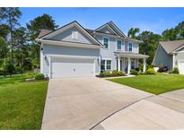 Charming two-story home with light blue siding, a two-car garage, and a well-maintained front yard at 818 Mourning Dove Dr., Myrtle Beach, SC 29577