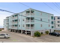 Three story condo building featuring light blue siding and white railings and trim at 824 N Waccamaw Dr. # 204, Murrells Inlet, SC 29576