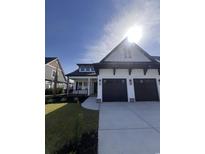 Stunning two-story home featuring a three-car garage, landscaped yard, and charming front porch at 5009 Middleton Dr., Myrtle Beach, SC 29579
