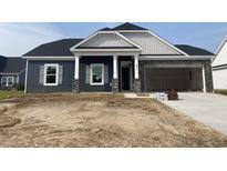 Charming single-Gathering home with stone accents, gray siding, and inviting covered entryway at 977 Oak Hollow St., Longs, SC 29568