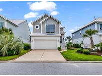 Charming two-story home features a neatly kept front yard, white garage, and a classic coastal architectural style at 104 Splendor Circle, Murrells Inlet, SC 29576
