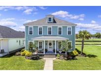 Charming two-story home with a welcoming front porch, well-manicured lawn, and beautiful landscaping at 1106 Tarpon Pond Rd., North Myrtle Beach, SC 29582